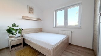 sypialnia z wygodnym łózkiem i pojemną szafą w jasnych kolorach