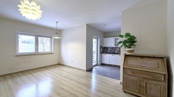 Salon z wnęką kuchenną w zabudowie i wyjściem na balkon. Biuro Nieruchomości Bielsko-Biała